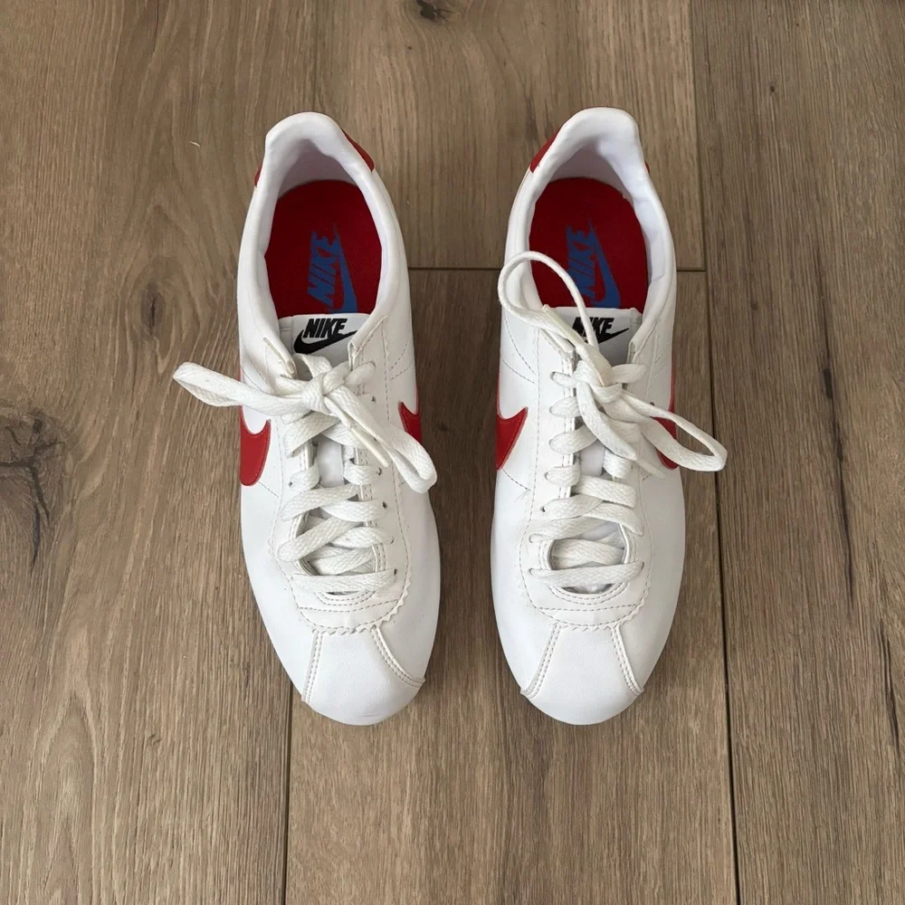 Nike Women's White Sneakers with Red Swoosh and Blue Accent